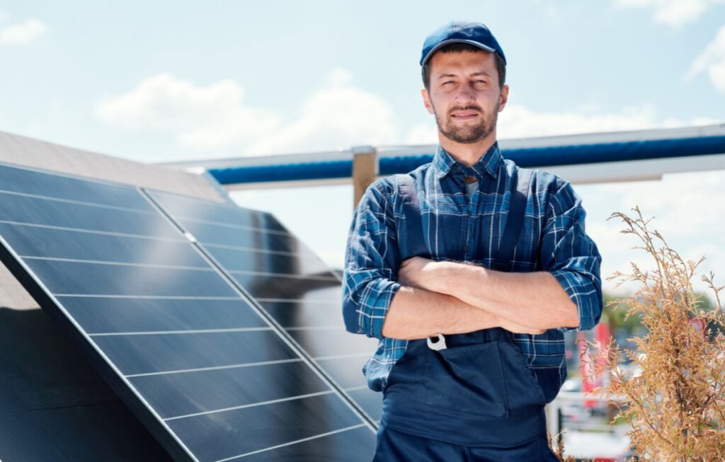 man standing behind solar panels